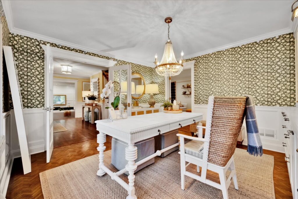 Dining room with crystal chandelier, wallpaper and herringbone floors